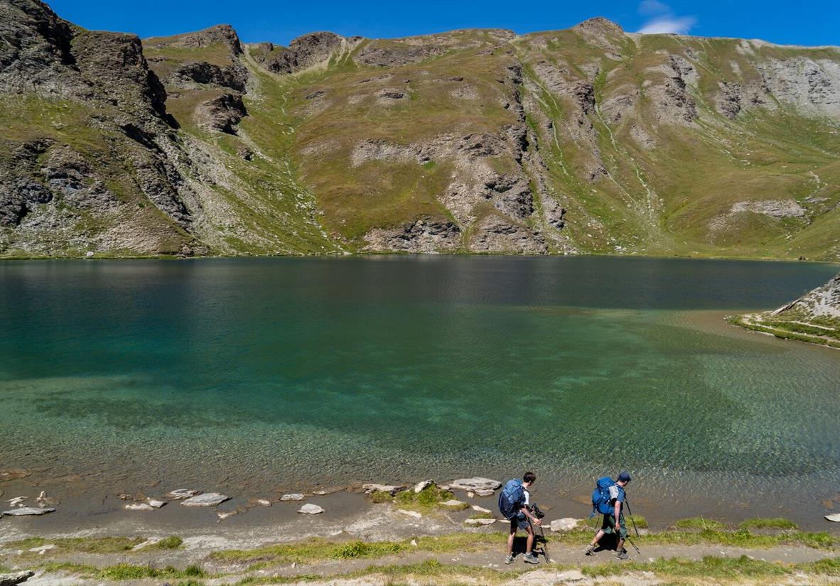 Hiking along a mountain lake in the Queyras