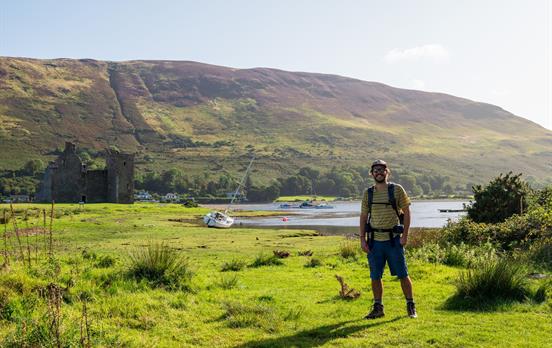 Wanderer mit Lochranza Castle in der Ferne